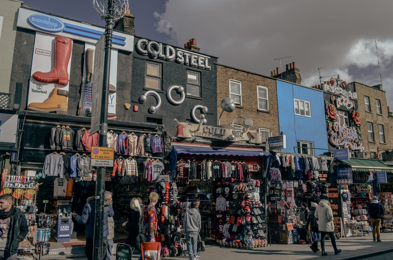 A vibrant street view of Camden Market in London showcasing quirky fashion shops and bustling activity.